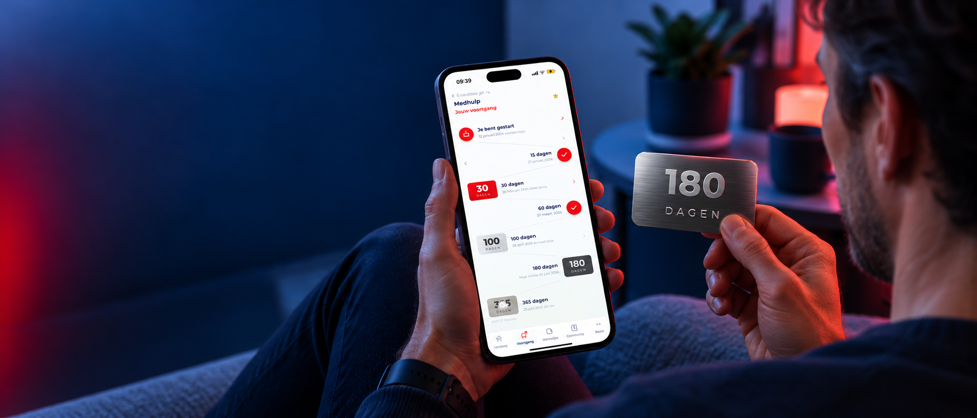 Iemand houdt een metalen 180-dagenkaart vast naast de app